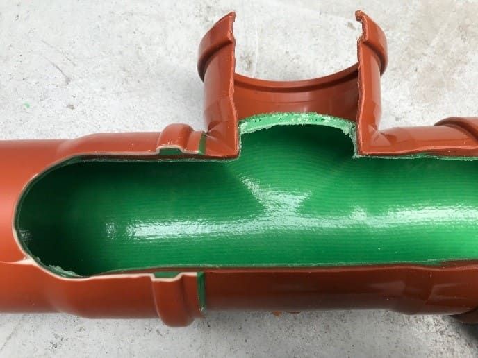 Intérieur vert d'un raccord de tuyau en plastique brun avec une découpe latérale ouverte