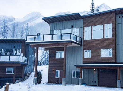 Modern brown apartment building with balconies in a snowy mountain setting