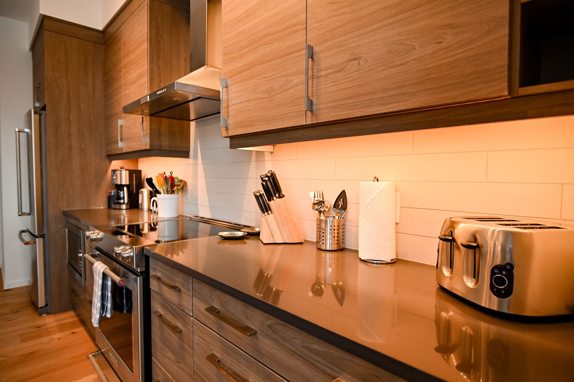 Modern kitchen with wooden cabinets, dark countertops, stove, and countertop appliances