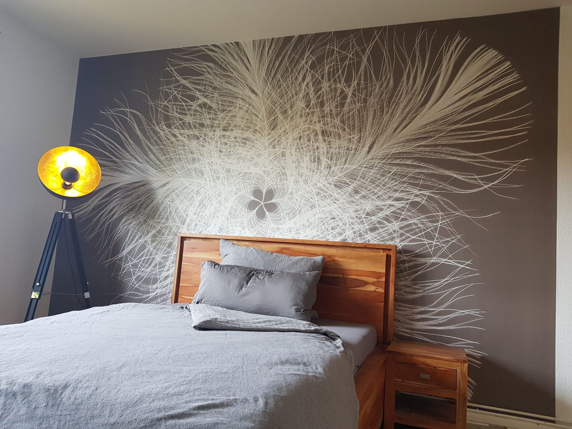 Ein Schlafzimmer mit Bett, Nachttisch und Lampe