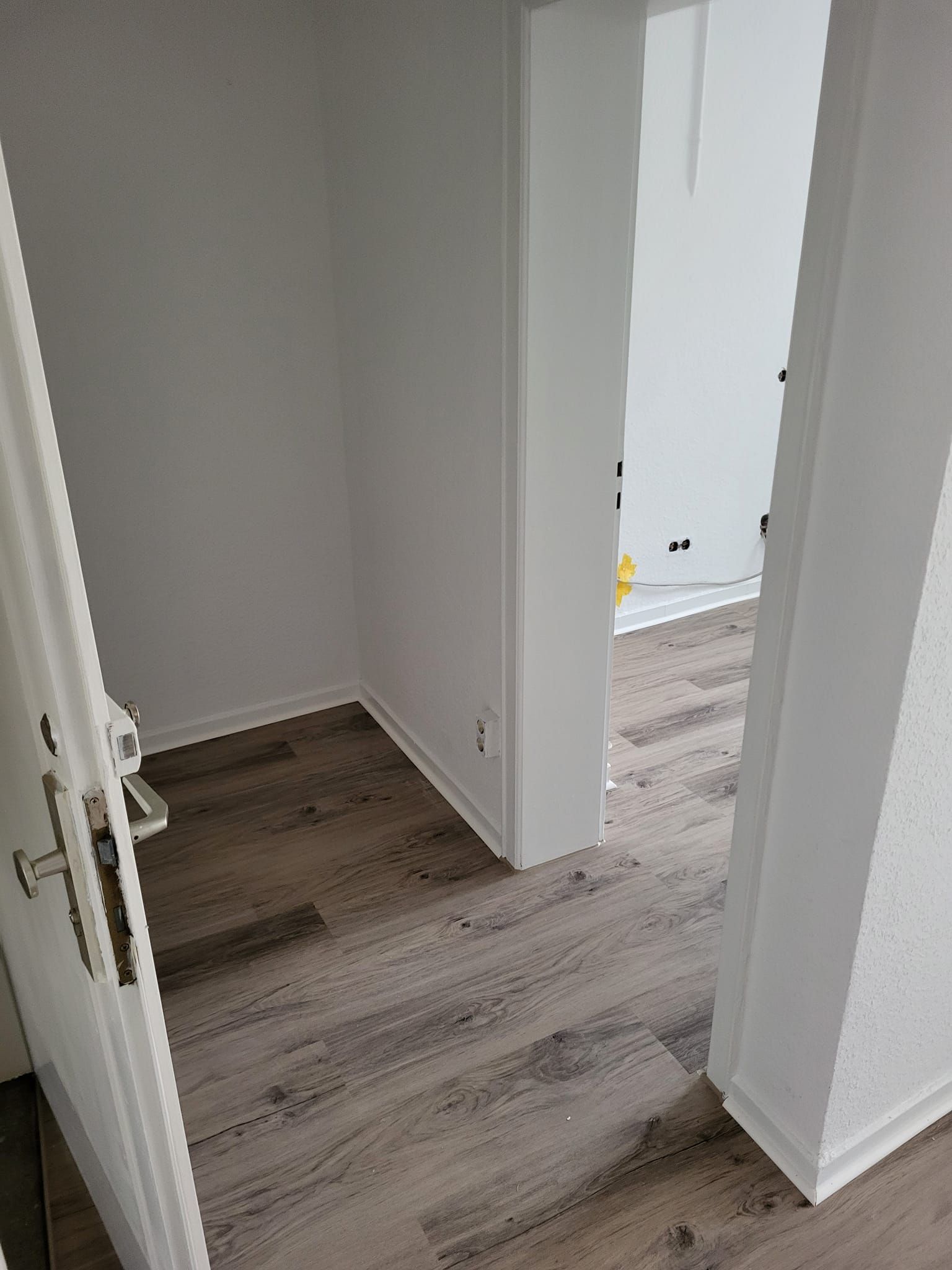 Ein Raum mit Holzboden und weißen Wänden.