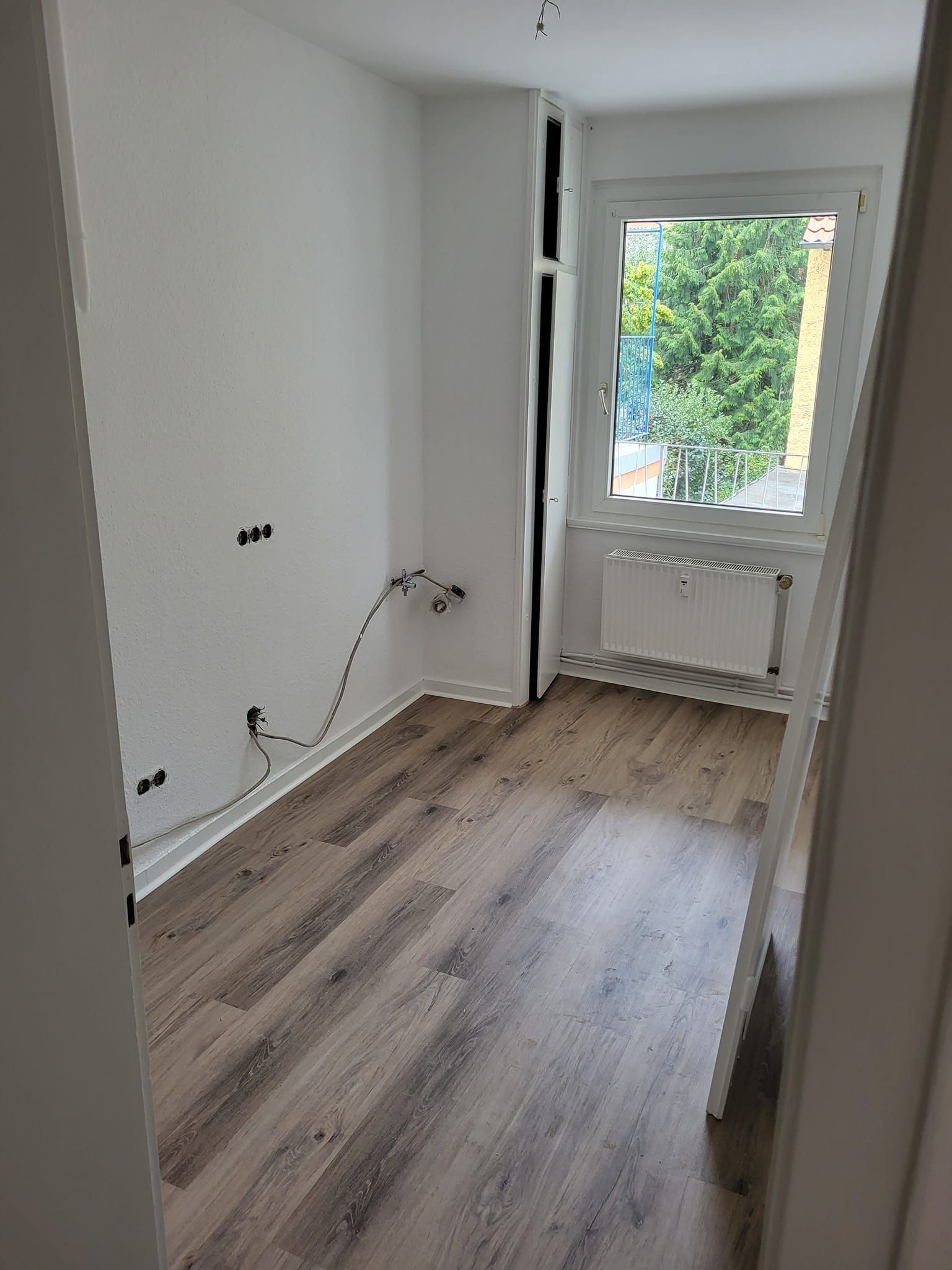 Ein leerer Raum mit Holzboden und Fenster.