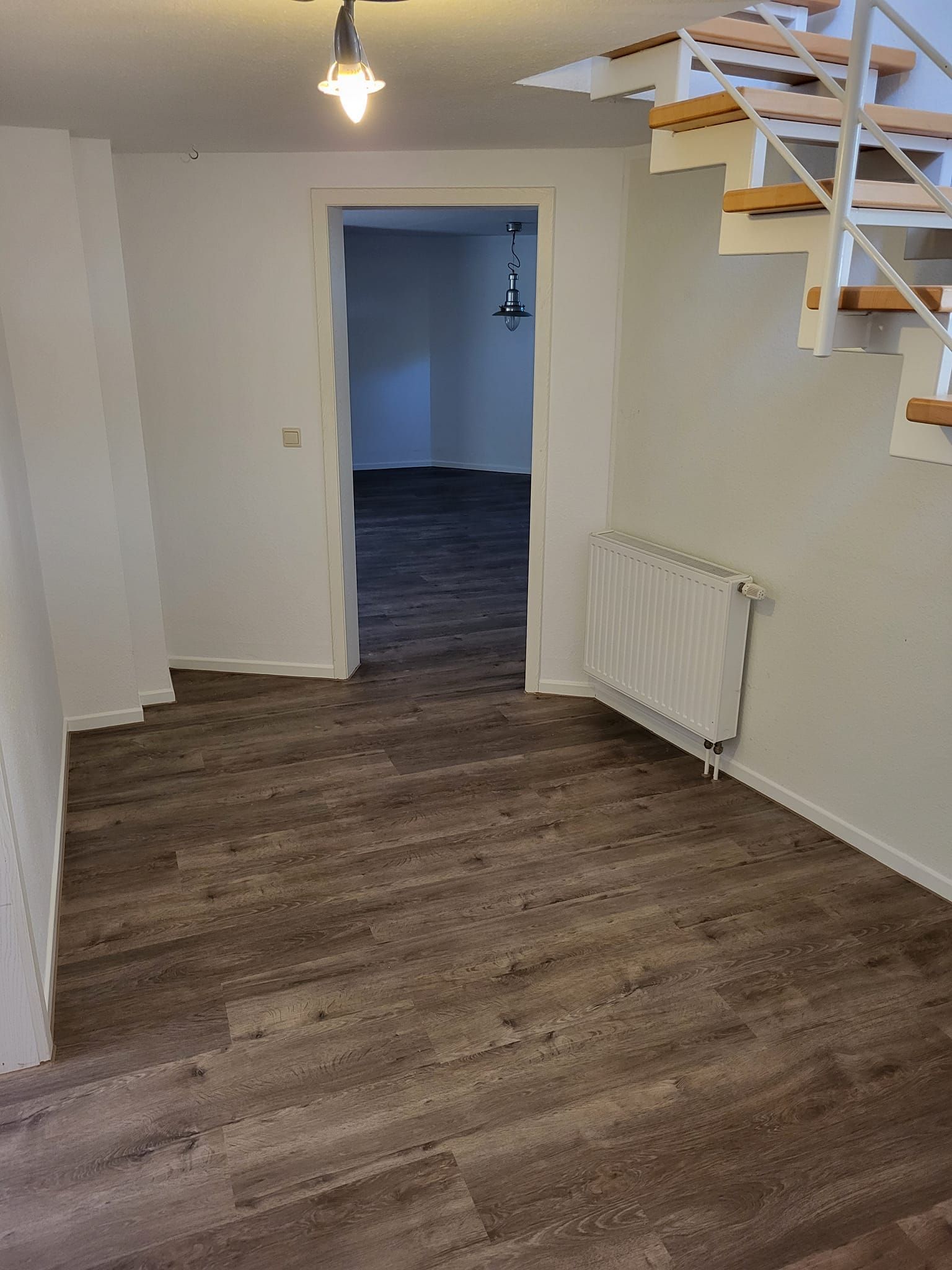 Ein leerer Raum mit Holzboden und Holztreppe.