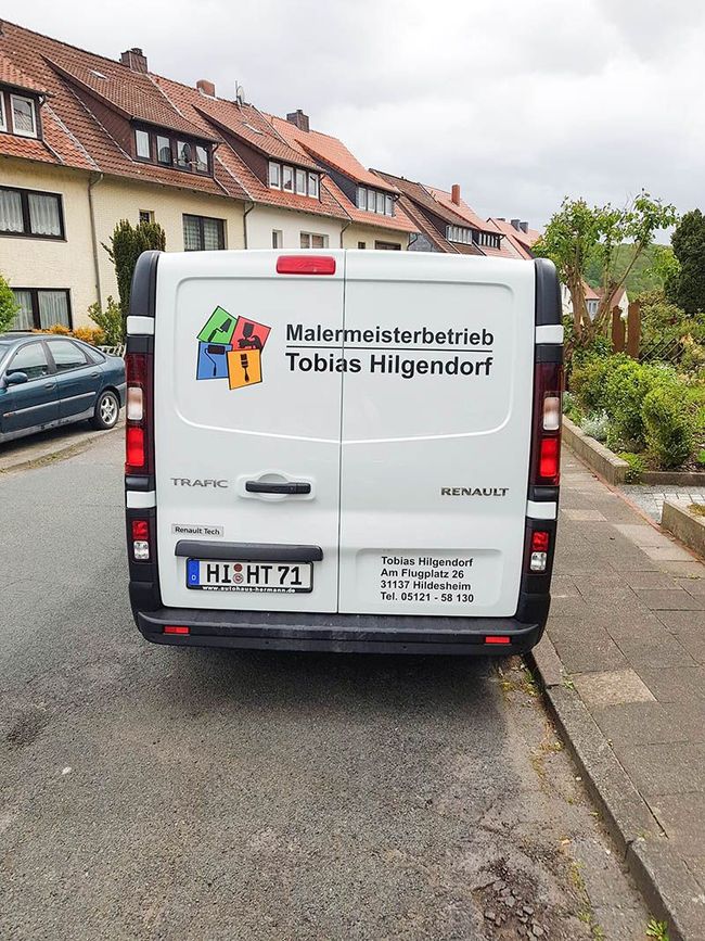 Ein weißer Lieferwagen steht am Straßenrand.