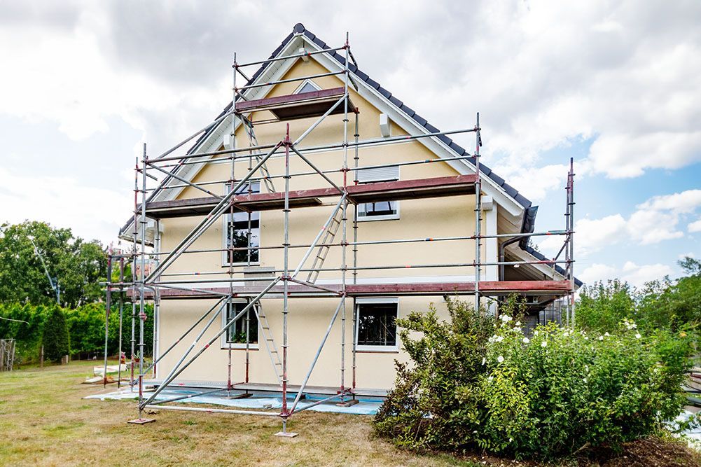 Es wird ein Haus mit Gerüst darum herum gebaut.