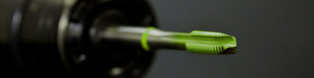 Eine Nahaufnahme eines grünen Schraubenziehers auf einer schwarzen Oberfläche.