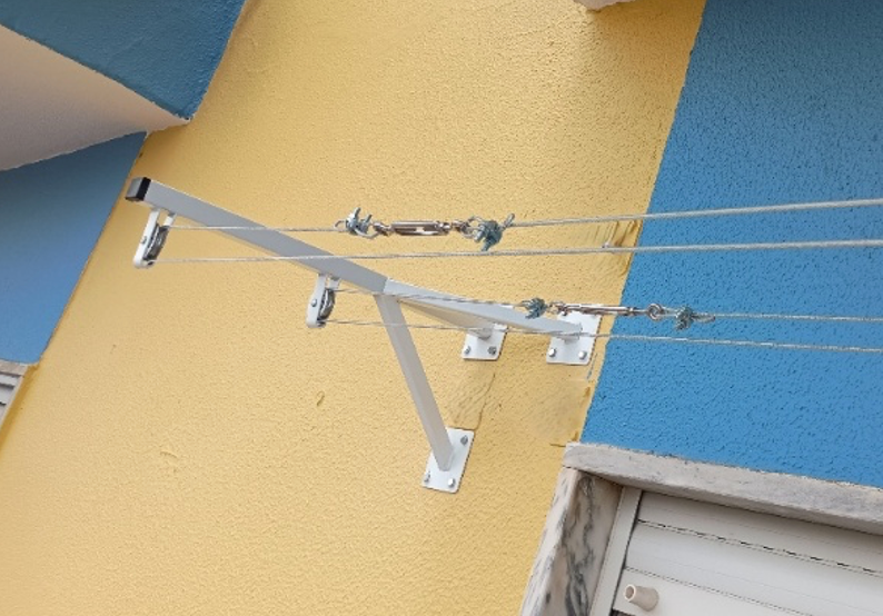 Uma pessoa está usando uma furadeira e um martelo para consertar uma dobradiça de porta.