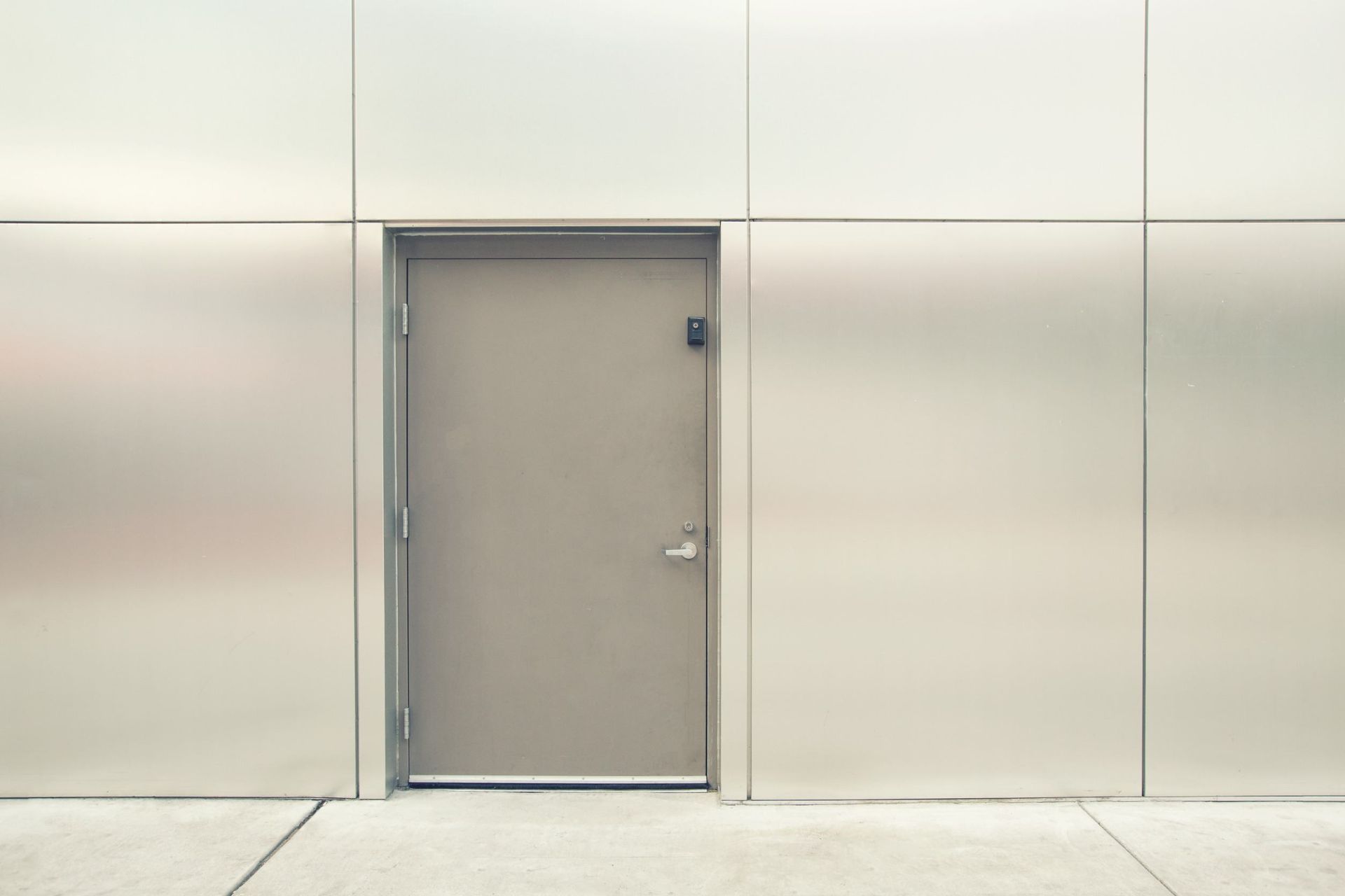 Hay una puerta en el medio de una pared de acero inoxidable.