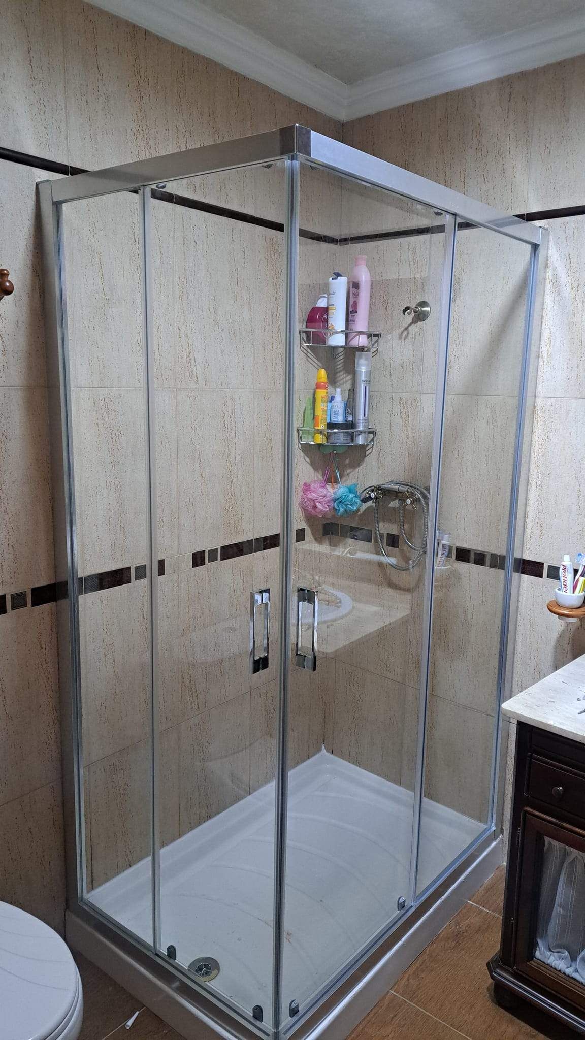 Un baño con cabina de ducha y un inodoro.