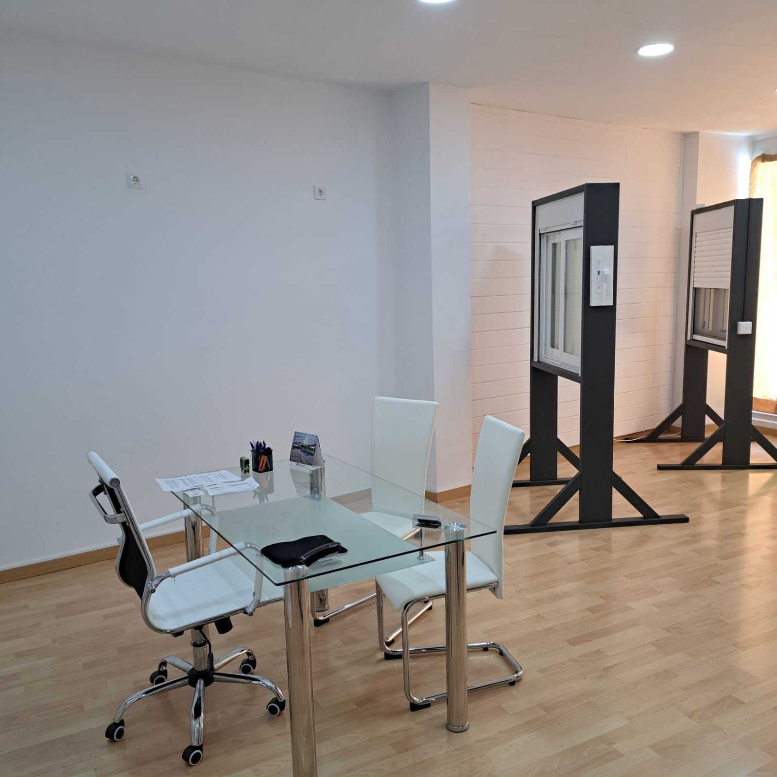 Una habitación con una mesa de cristal y sillas.