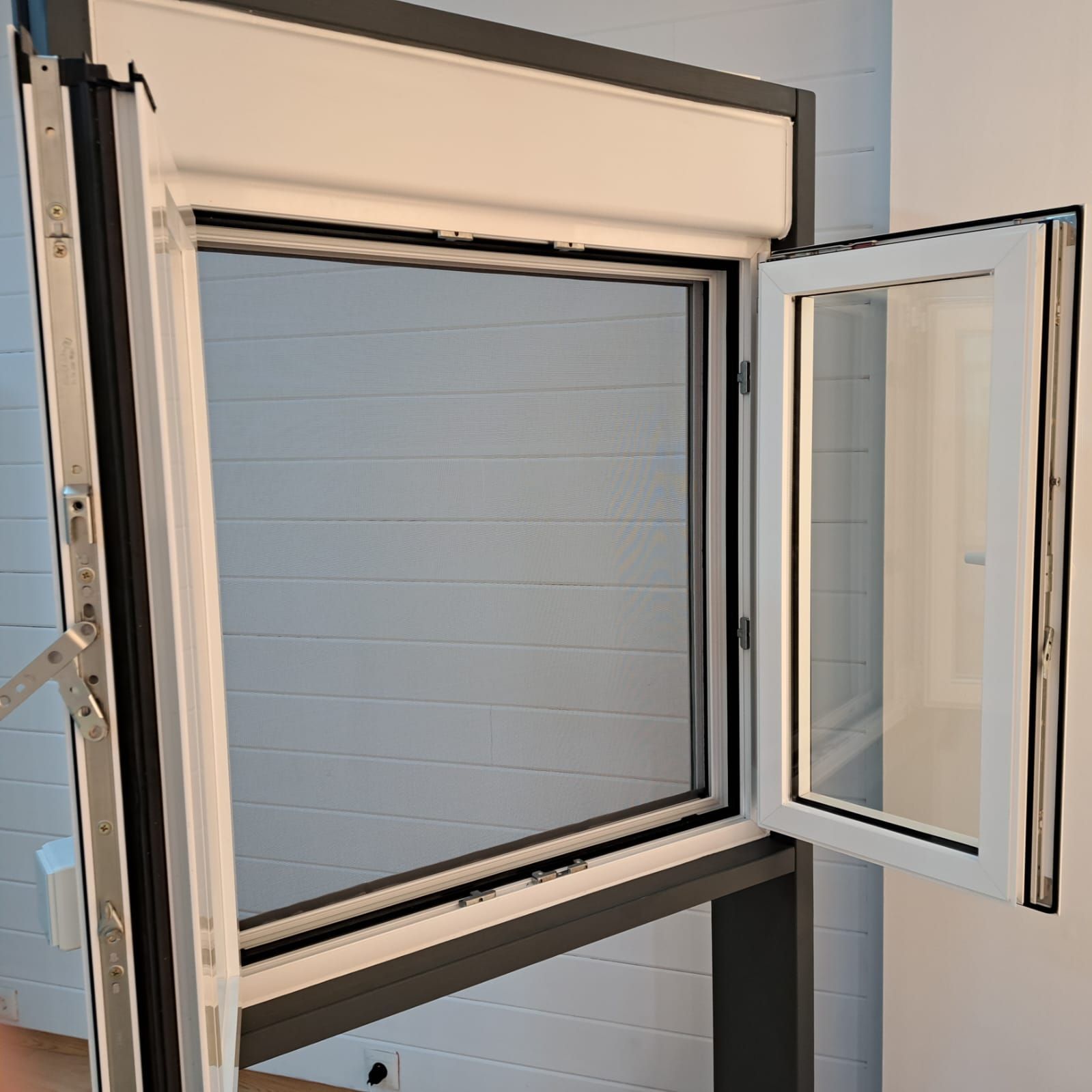 Una ventana está abierta en una habitación con una pared azul.