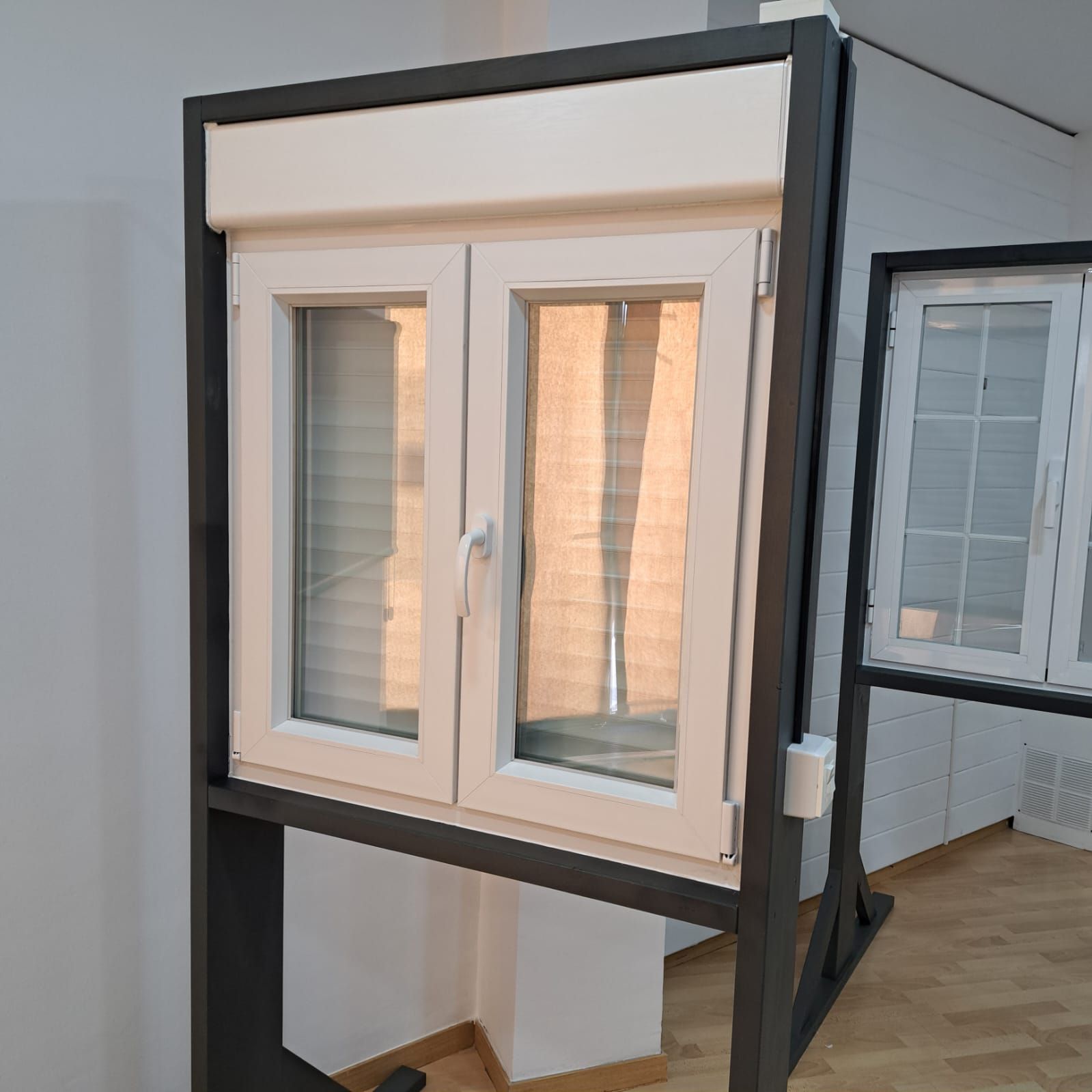Una ventana blanca con un marco negro está expuesta en una habitación.