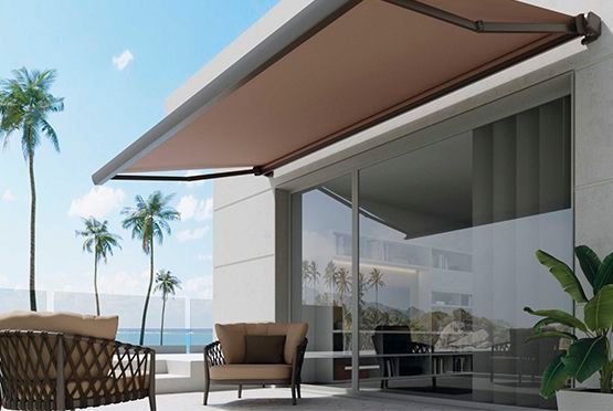 Un patio con un sofá y sillas bajo un toldo.