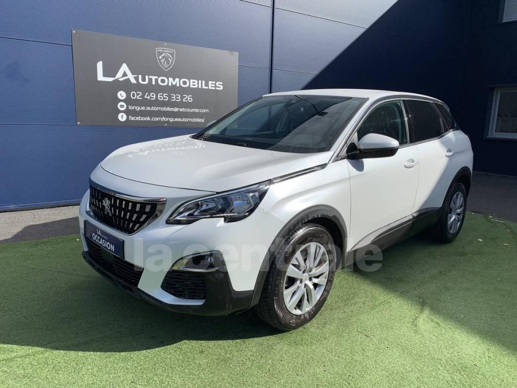 SUV Peugeot 3008 blanc garé devant un bâtiment bleu avec panneau LA AUTOMOBILES