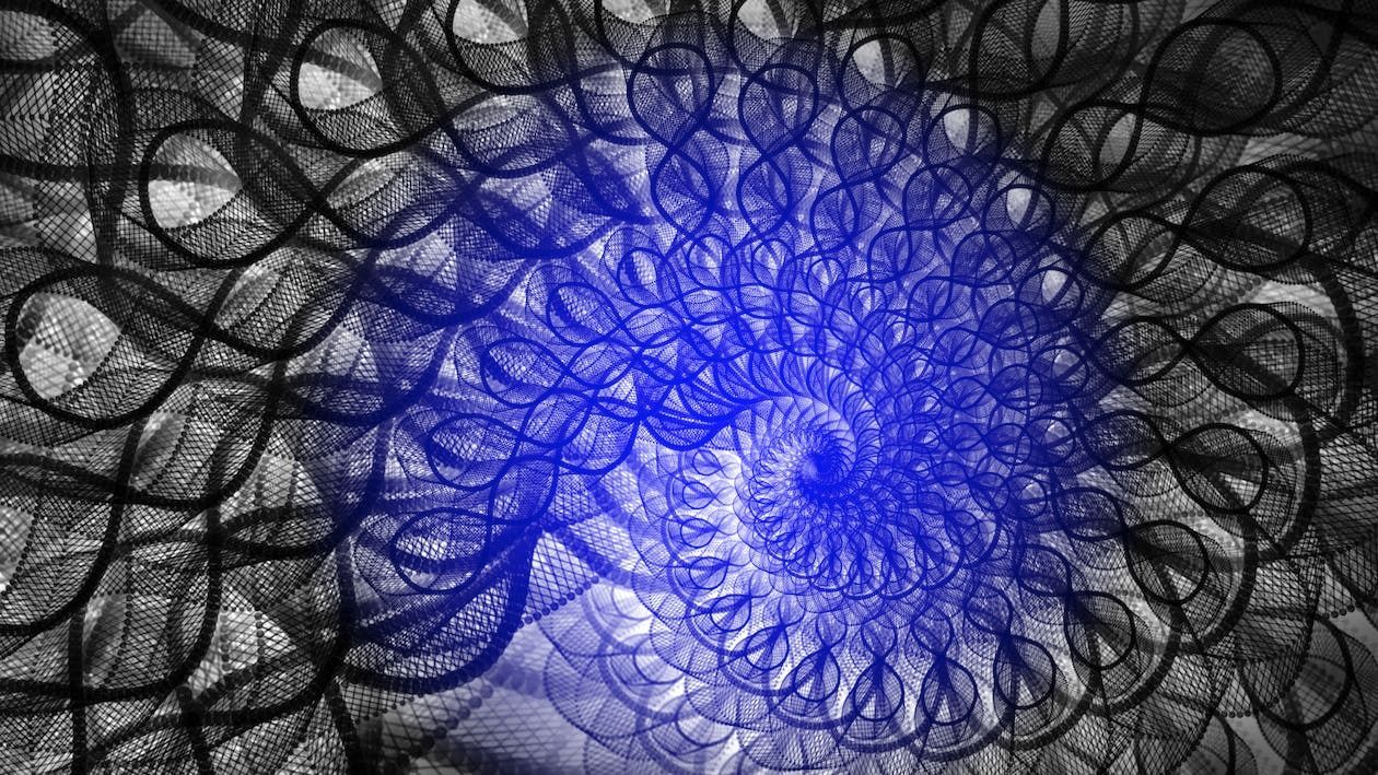 Espiral azul que gira y emana desde el centro, rodeada de intrincados patrones negros y grises.