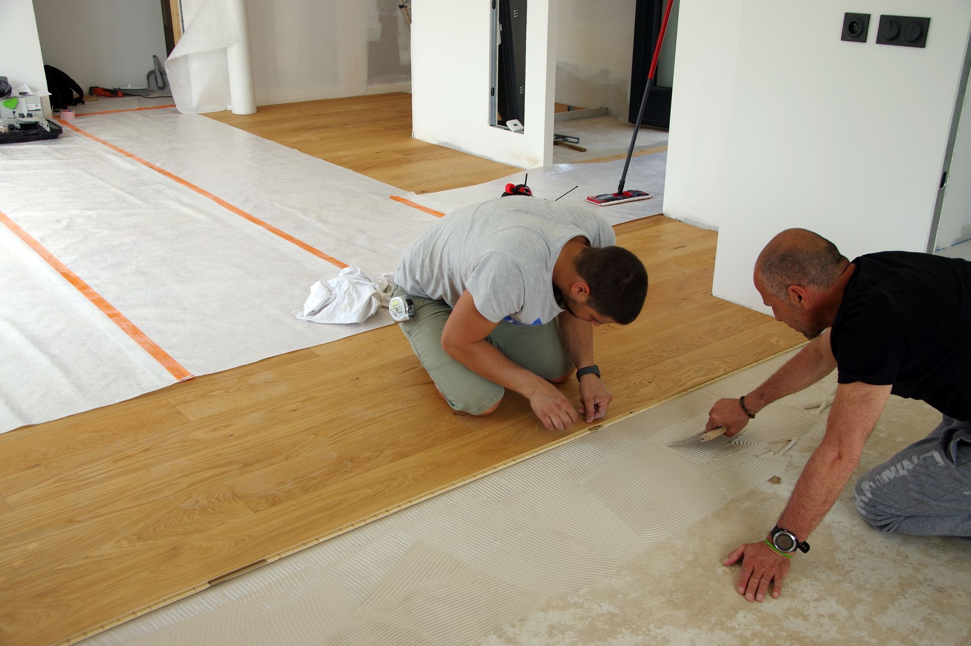Deux hommes en train de poser du parquet flottant