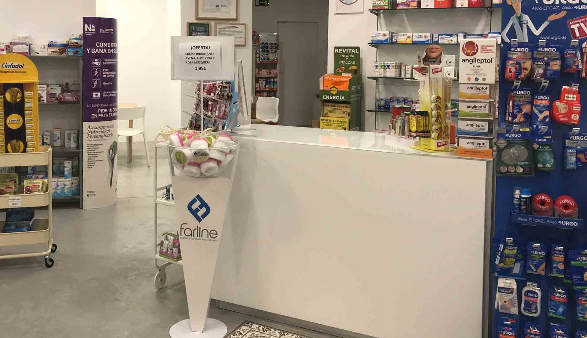 Una farmacia con mostrador y expositor de dulces.