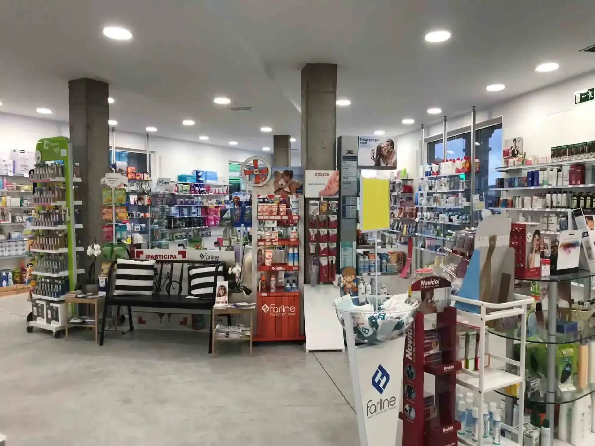 El interior de una farmacia con un banco en el medio de la habitación.