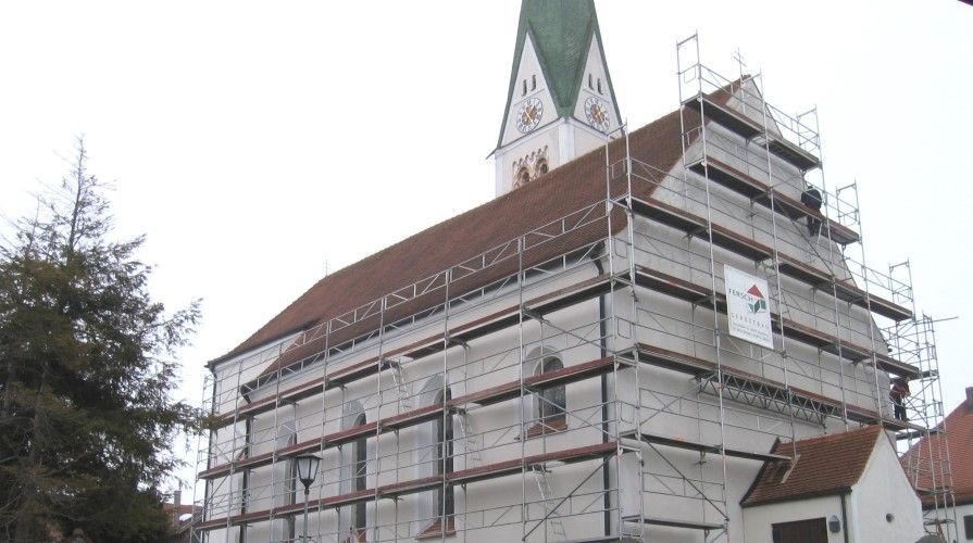 ein Haus, das mit Gerüst gebaut wird und einen Kamin hat