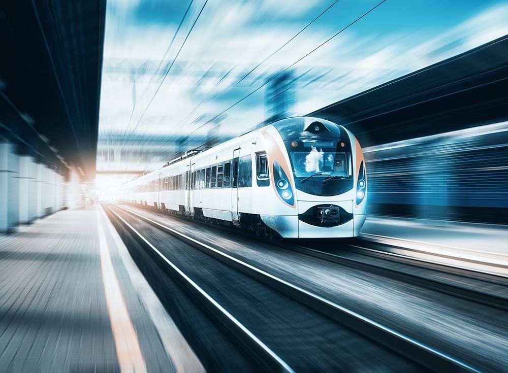 Un tren está bajando por las vías en una estación de tren.