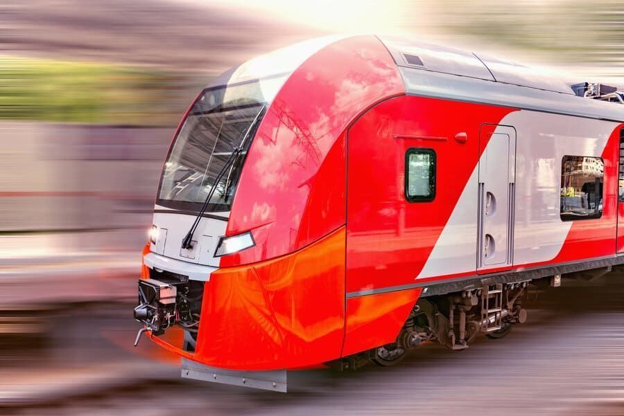 Un tren rojo y blanco va por las vías.