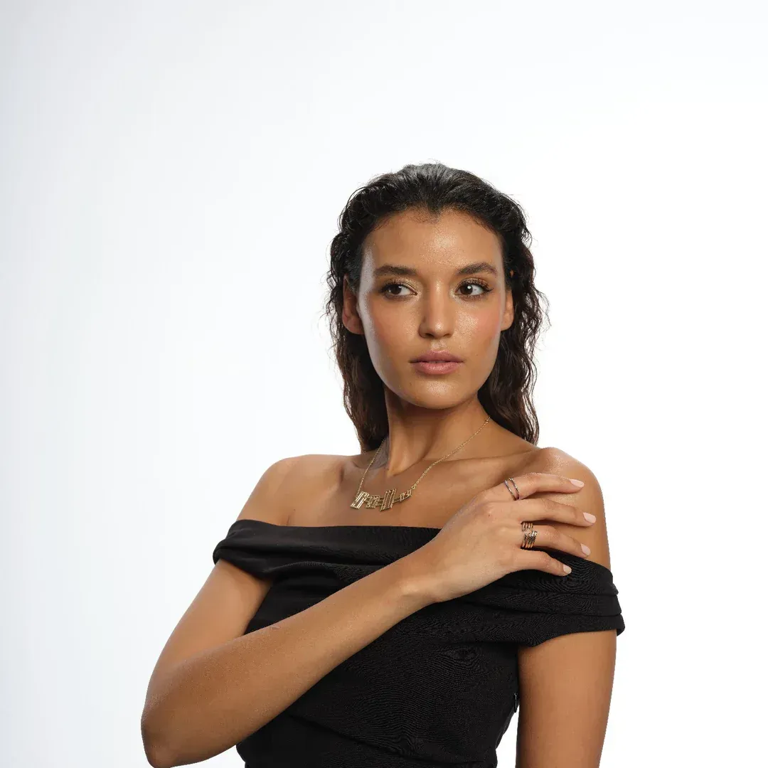 Eine Frau, die ein schwarzes schulterfreies Top und eine Halskette trägt
