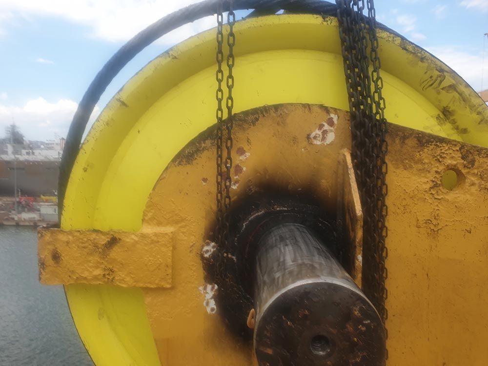 Ein großes gelbes Objekt wird an Ketten angehoben.