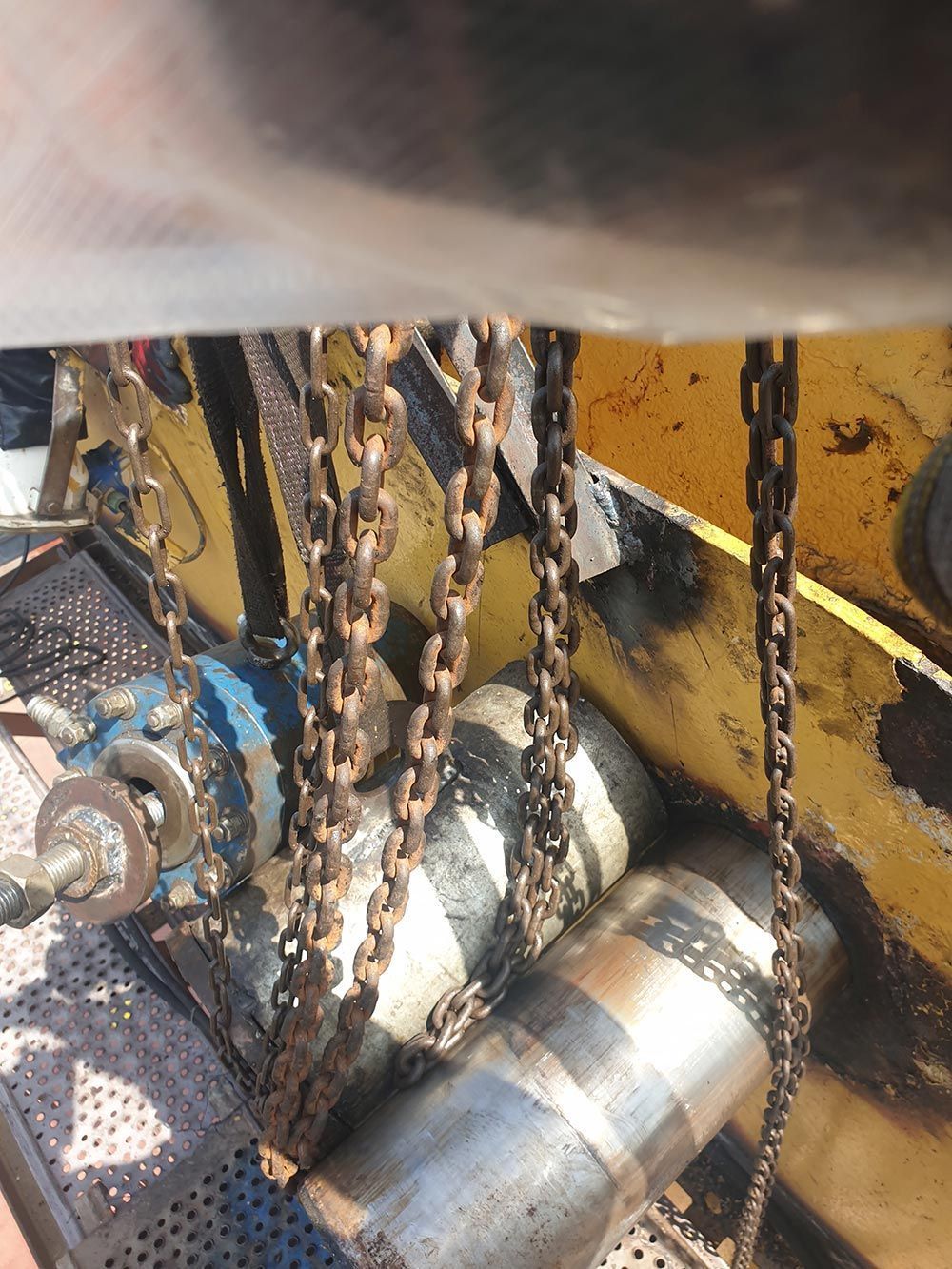 Eine Nahaufnahme einer Maschine mit daran hängenden Ketten