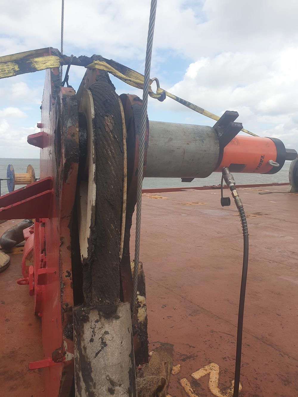 Ein großes Objekt liegt an einem Strand neben einem Gewässer.