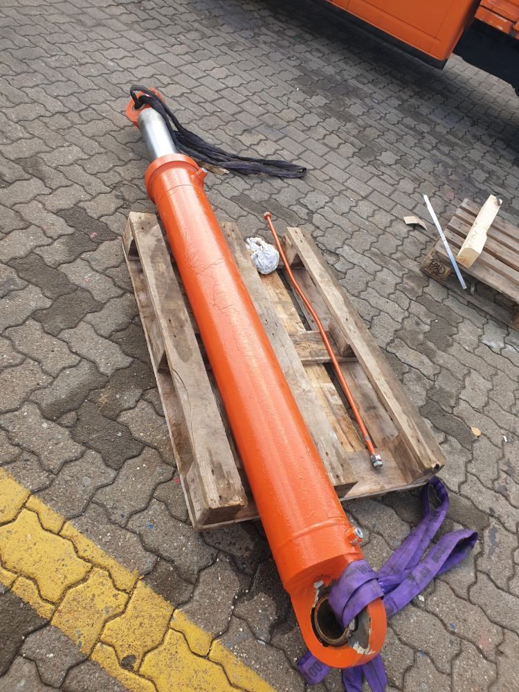 Ein großer orangefarbener Zylinder liegt auf einer Holzpalette