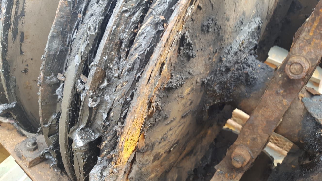 Eine Nahaufnahme eines rostigen Metallgegenstands mit viel Schmutz darauf.