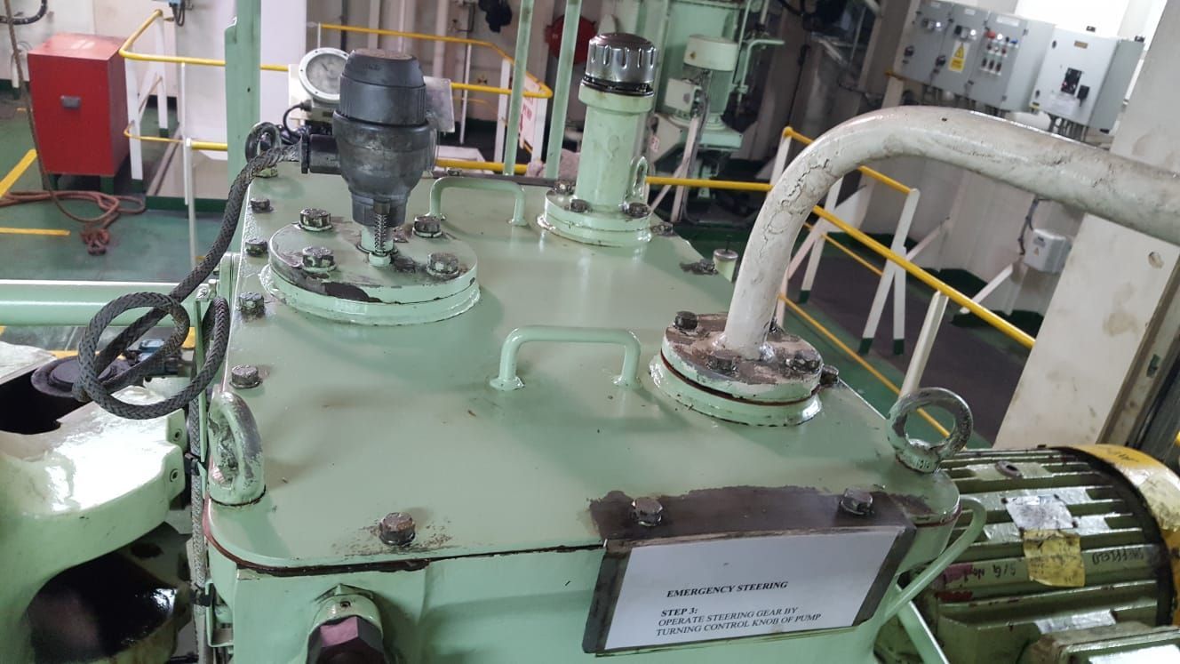 In einem Raum steht ein großer grüner Tank mit einem daran befestigten Schlauch.