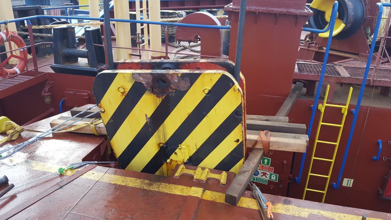 An der Seite eines Bootes befindet sich ein gelb und schwarz gestreifter Gegenstand.