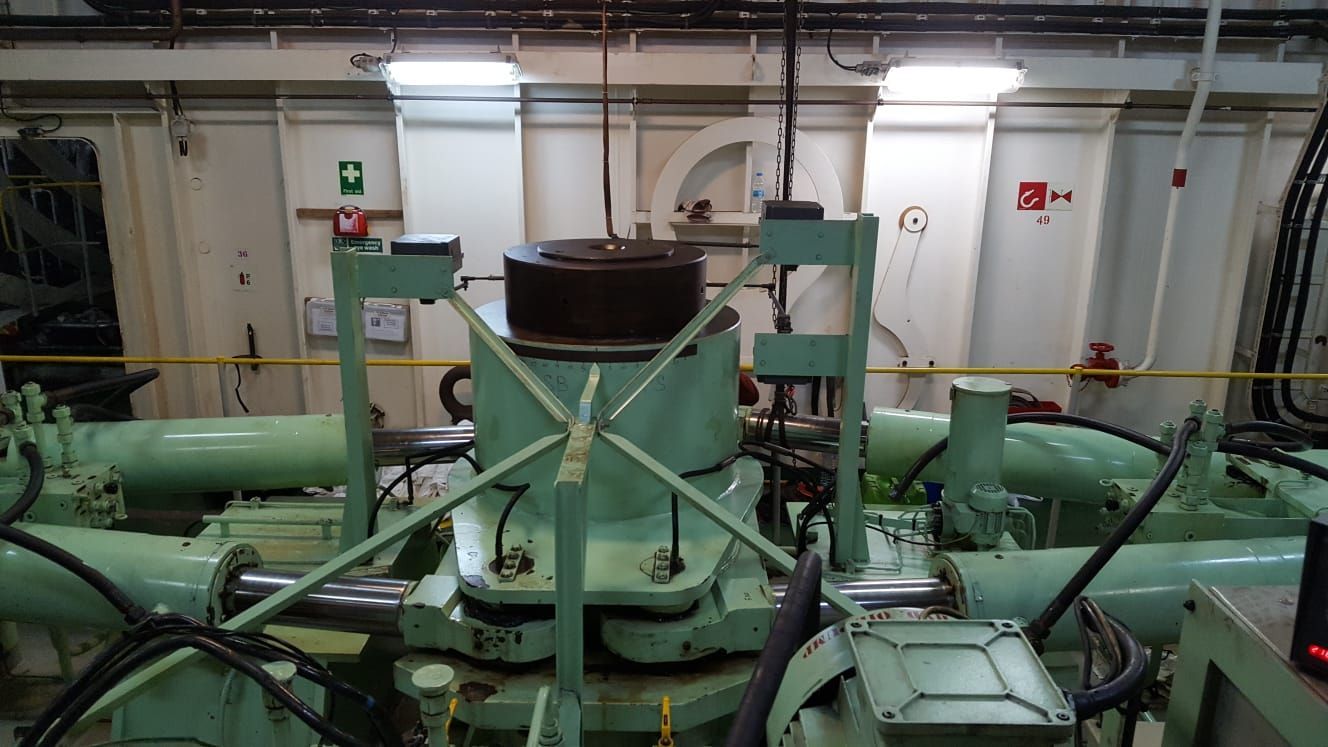 Eine große grüne Maschine steht in einem Raum auf einem Schiff.