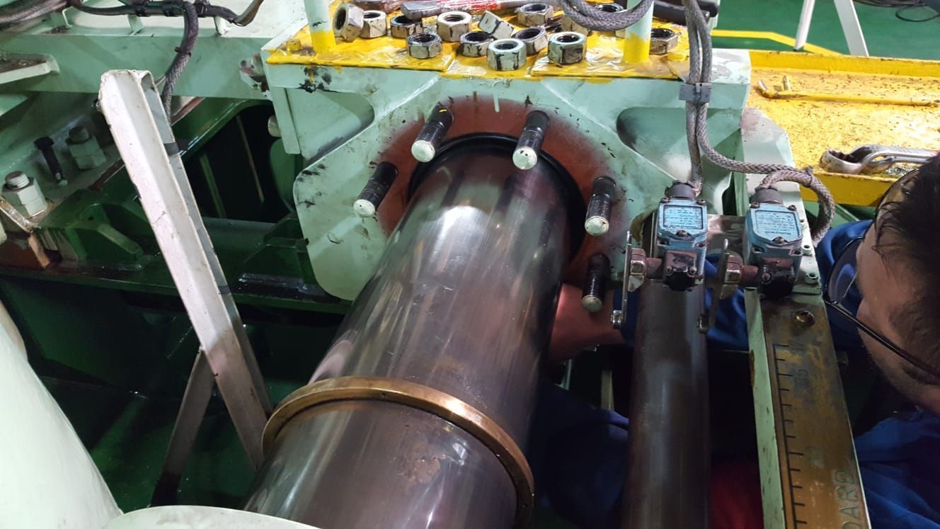 Ein Mann arbeitet in einer Fabrik an einem großen Rohr.