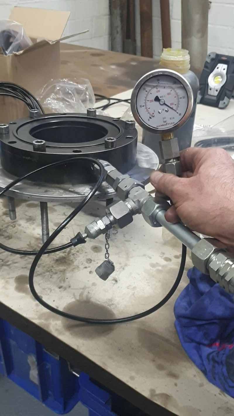 Eine Person hält ein Druckmessgerät auf einem Tisch.