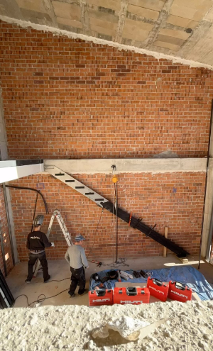 Un grupo de trabajadores de la construcción está trabajando en una pared de ladrillos.
