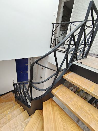 Una escalera de madera con barandilla de metal en una casa.
