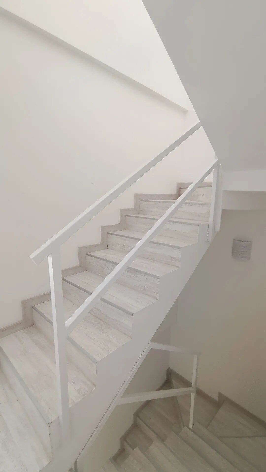 Una escalera blanca con una barandilla blanca en un edificio.