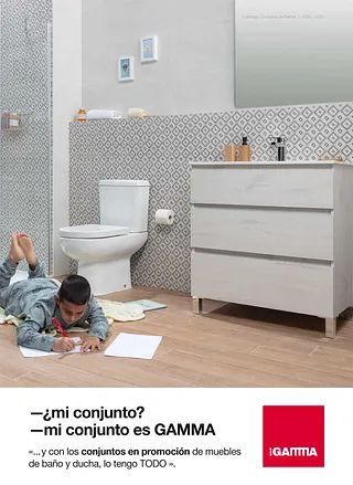 Un hombre está tendido en el suelo en un baño con inodoro, lavabo y espejo.
