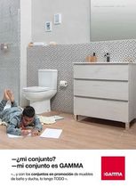Un hombre está tendido en el suelo en un baño con inodoro, lavabo y espejo.