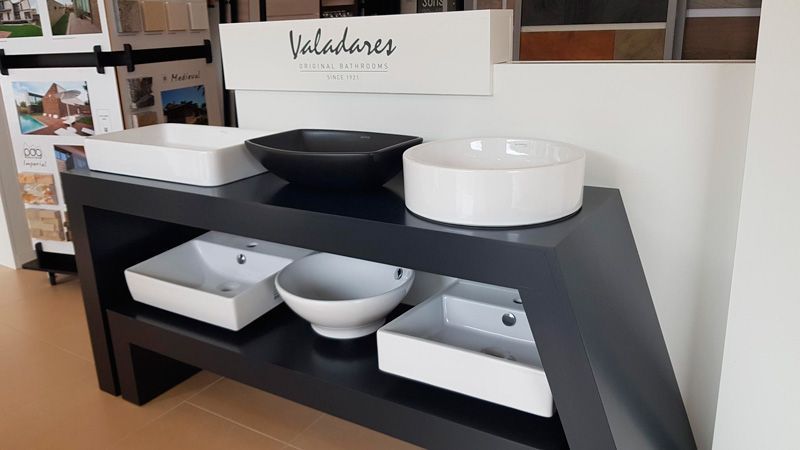 Una mesa con tres lavabos y un cartel que dice valladares