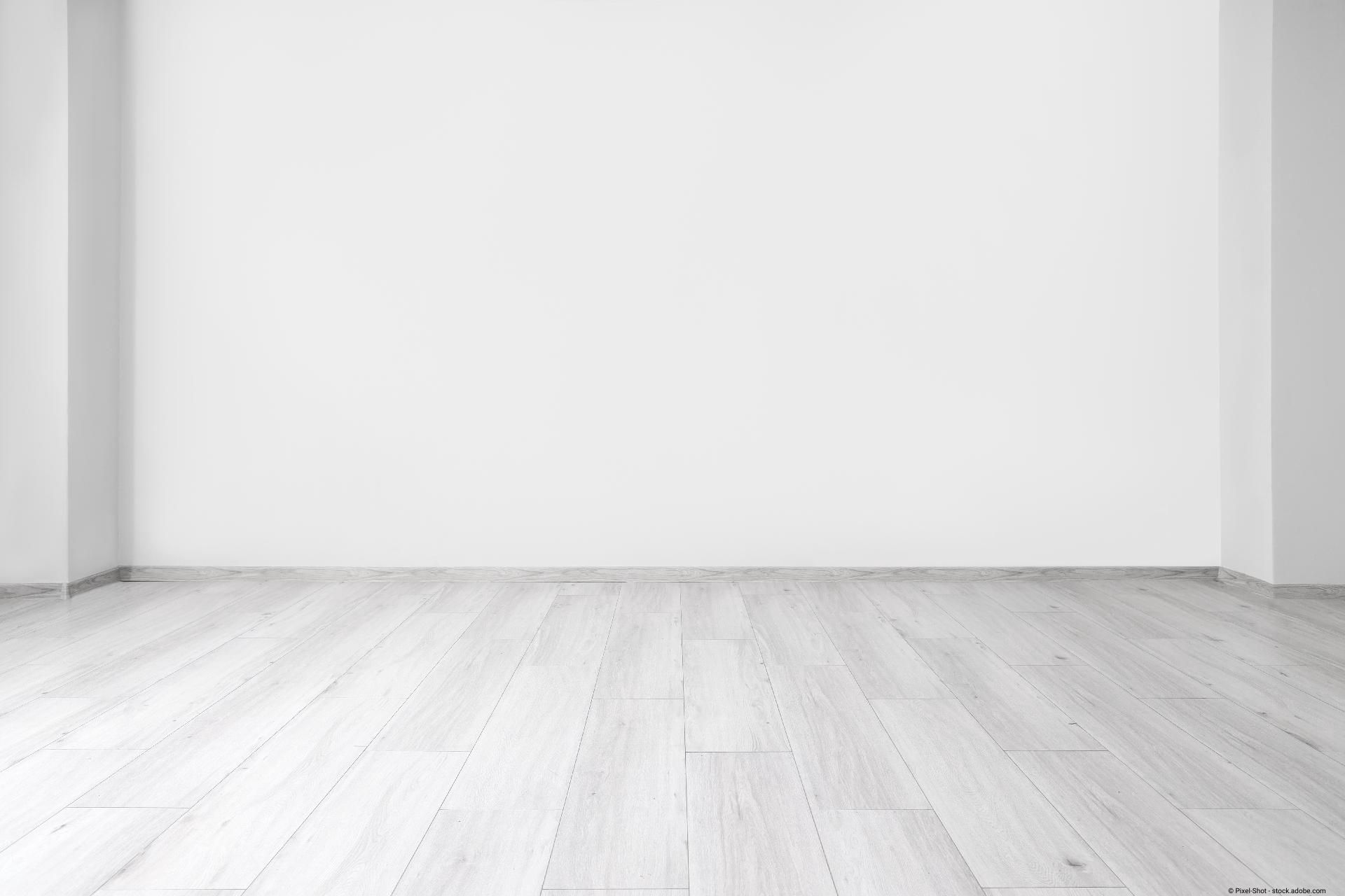 Ein heller Raum mit weiß-gräulichem Laminatboden