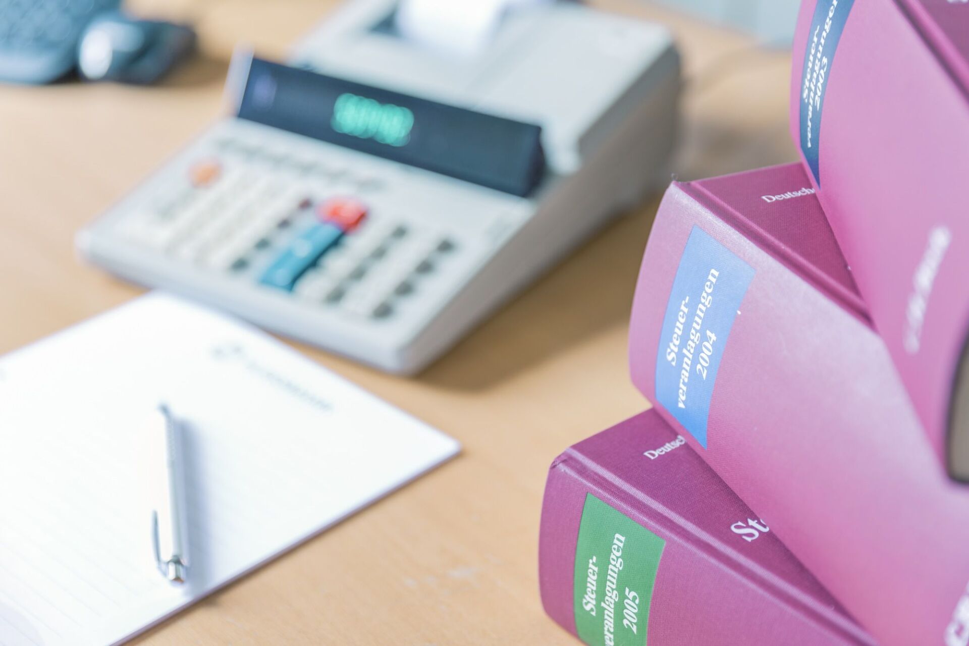 Fachliteratur und Rechenmaschine auf einem Schreibtisch