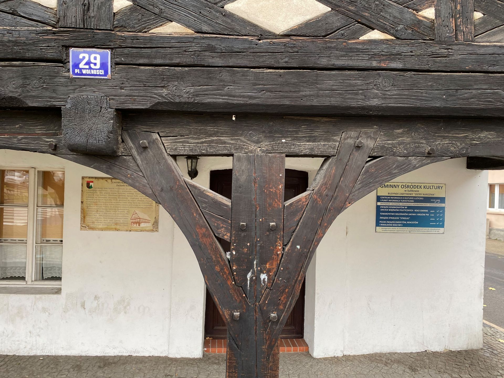 Fachwerkfassade mit Hausnummer 29 und gebogener Holzstütze.