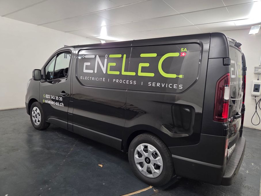 Fourgonnette de service ENELEC noire avec logo, garée à l'intérieur d'un garage.