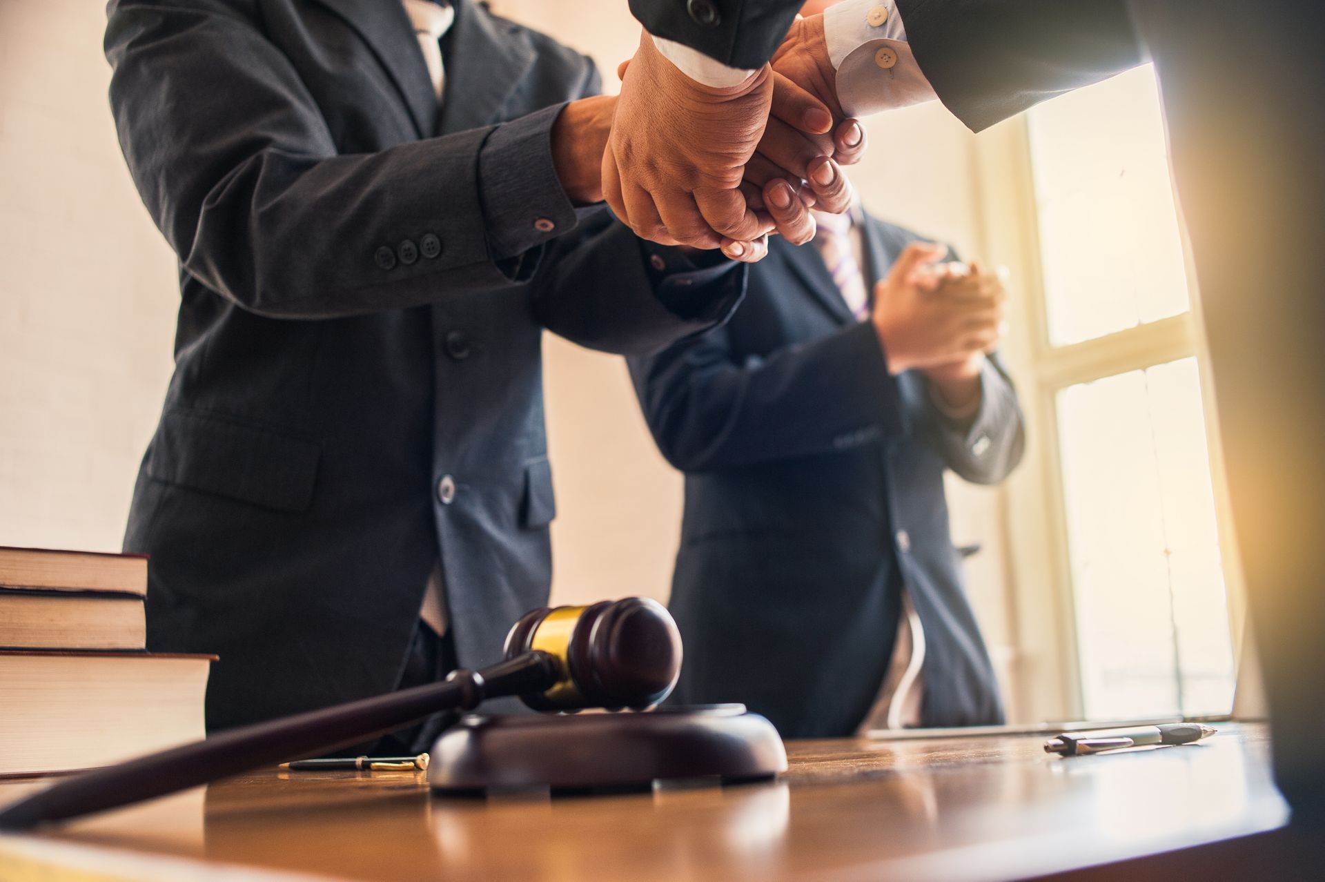 Individus se serrant la main, et marteau de la justice