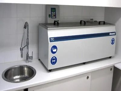 Bain-marie de laboratoire en acier inoxydable à côté d'un évier sur un comptoir carrelé