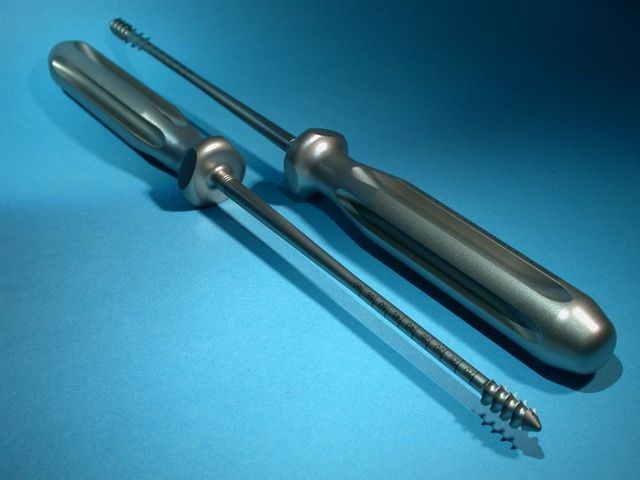 Deux tournevis en acier inoxydable sur fond bleu, l'un plat et l'autre cruciforme.