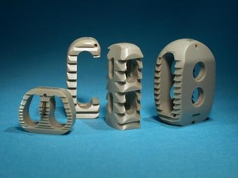 Trois lettres et formes mécaniques segmentées beiges sur une surface bleue, le tout sur un fond bleu foncé.